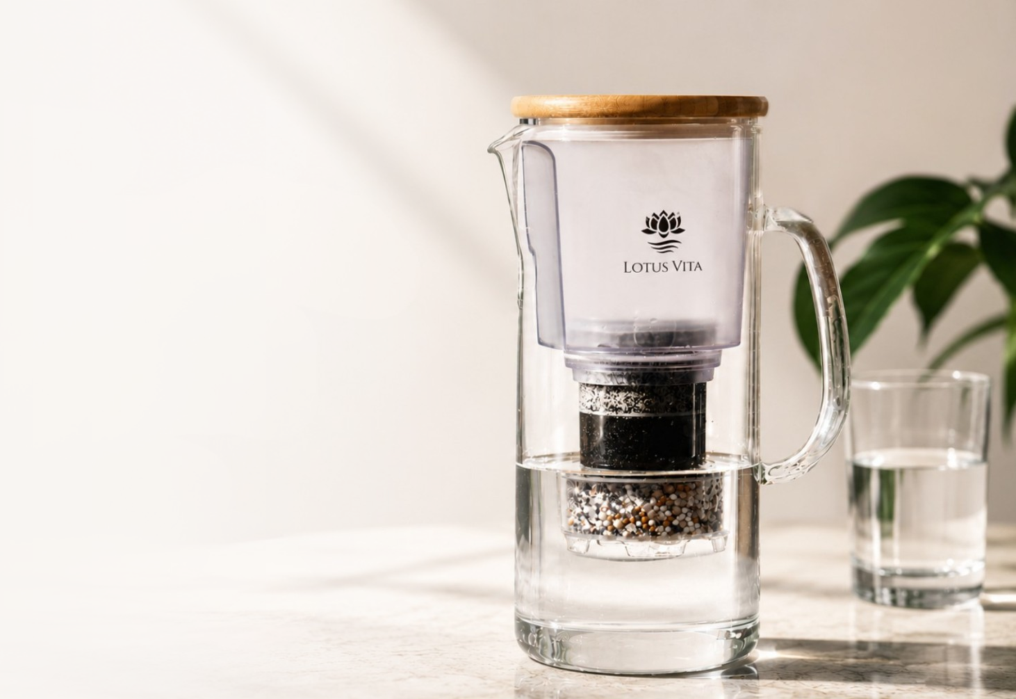 The Lotus Vita ENYA glass water filter pitcher with a wooden lid sits on a countertop, providing fresh, purified water.